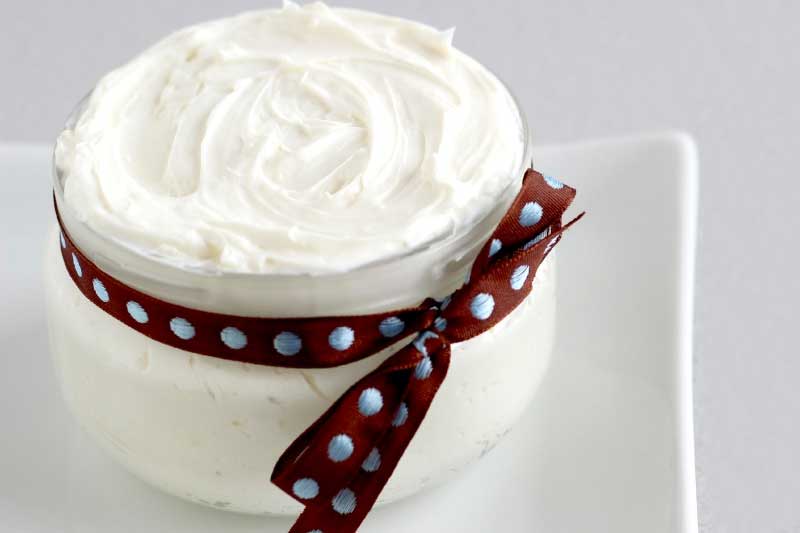 jar filled with white body butter with ribbon tied around the jar