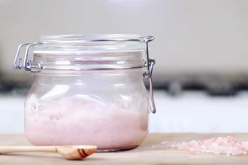 glass jar of pink body scrub