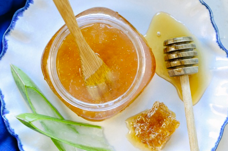 birdseye view of jar of honey and slices of aloe vera used in receipe