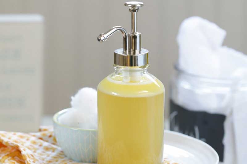 glass dispenser filled with foaming honey face cleanser