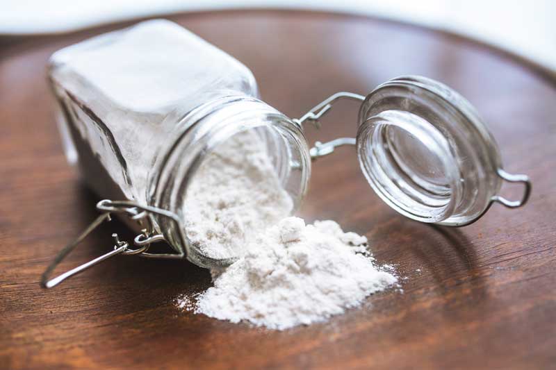 jar of flour on it's side with flour splilling out