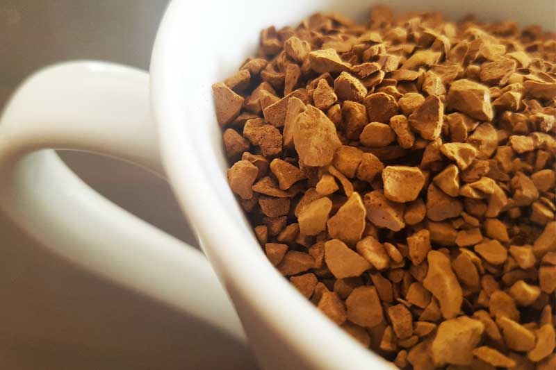 close up of coffee grounds in a white coffee cup